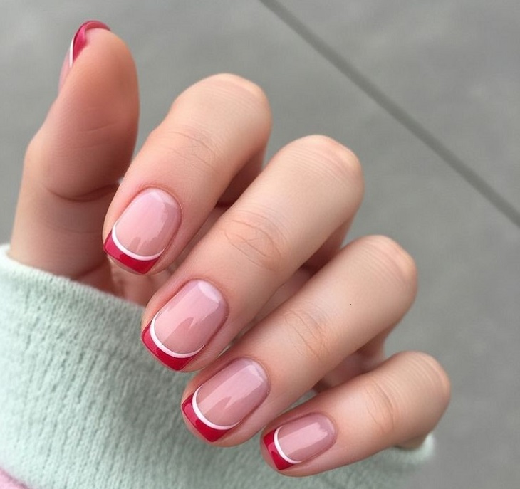 chic short rounded red French tip nails featuring a delicate white ribbon accent